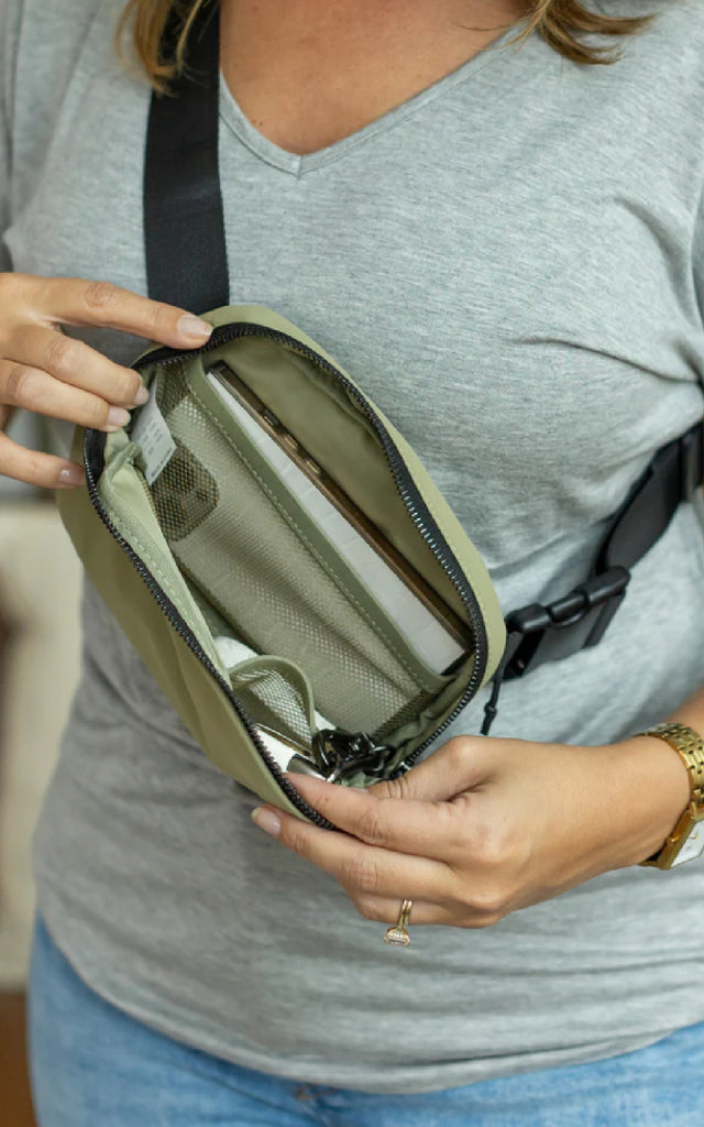 A bum bag unzipped, showing the interior mesh pockets. 