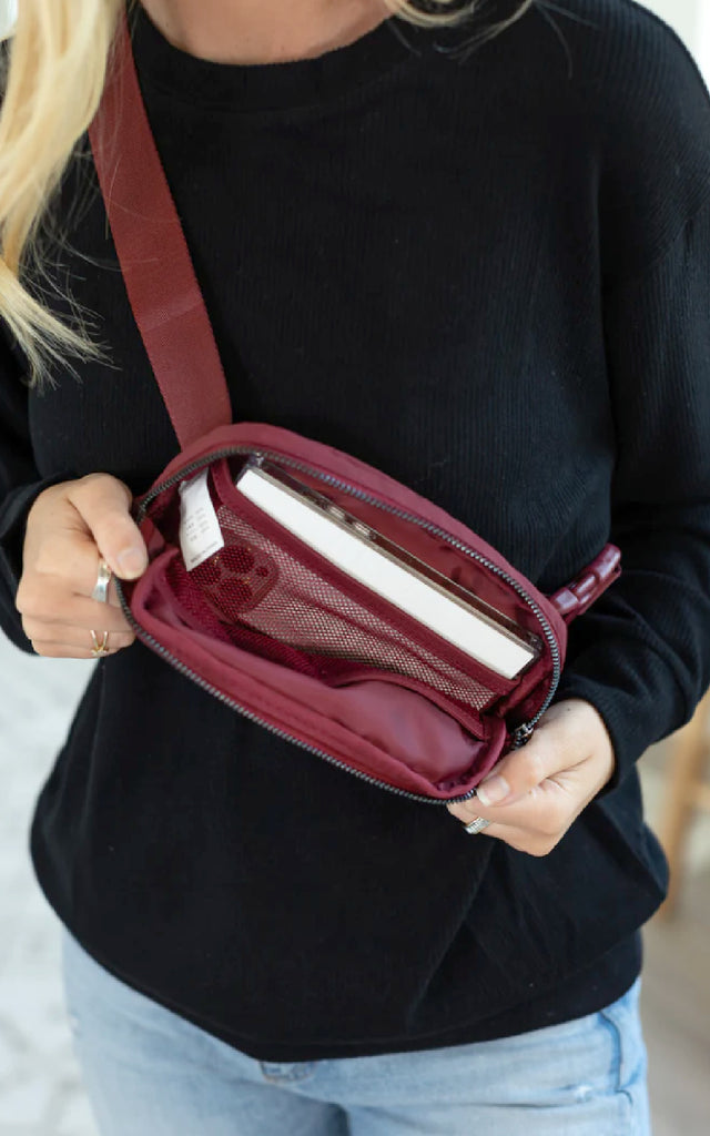 Woman showing the inside of a bum bag.
