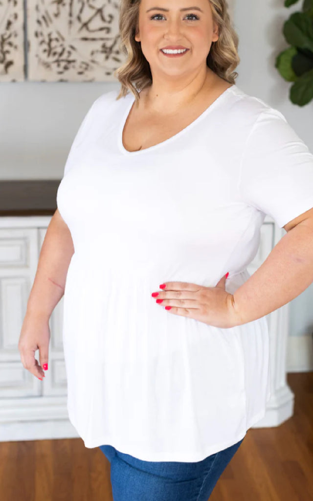 Woman wearing a white babydoll short sleeve top.