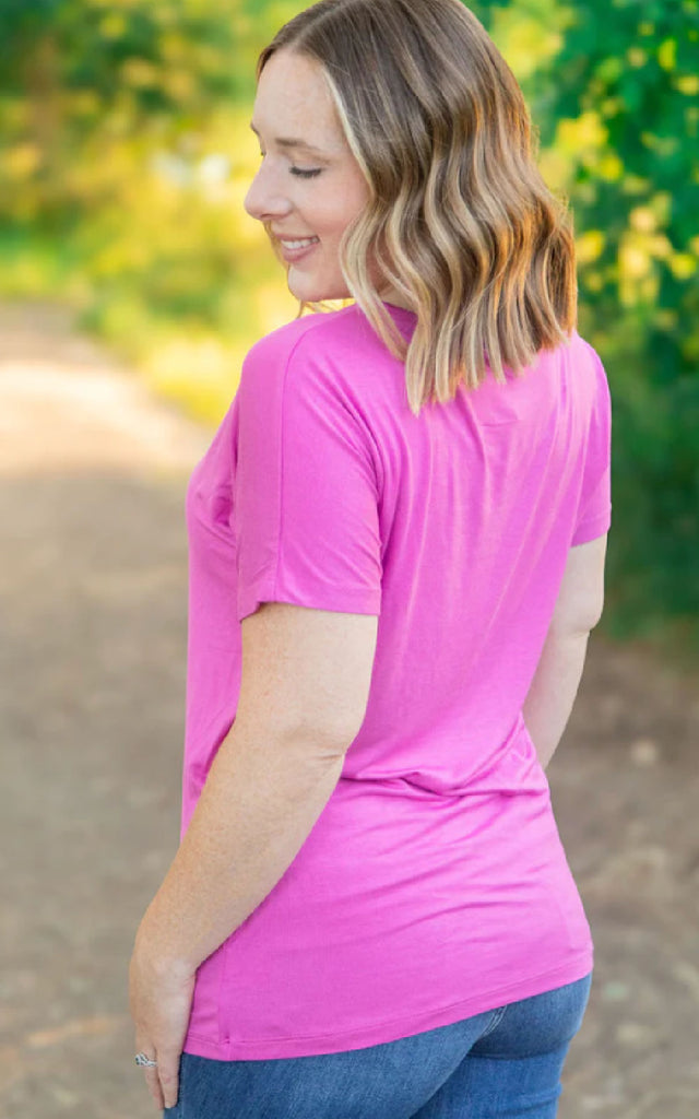 Woman wearing a bright pink, short sleeve casual tee.