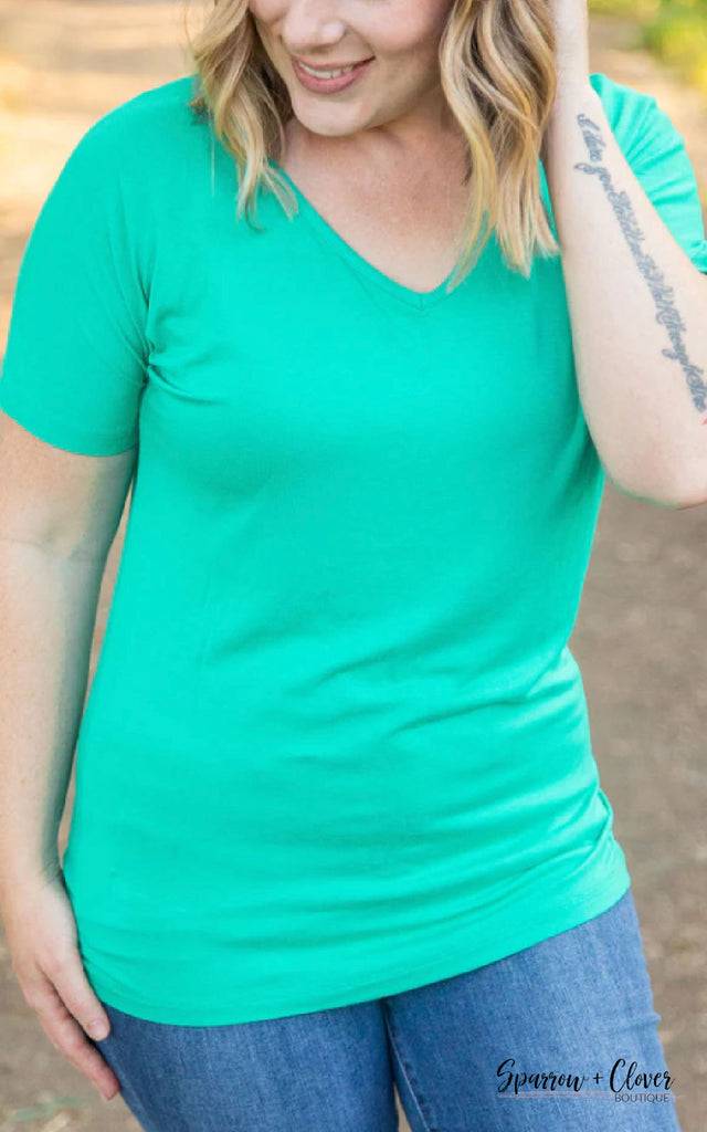 Woman wearing a green short sleeve top with a v neck.