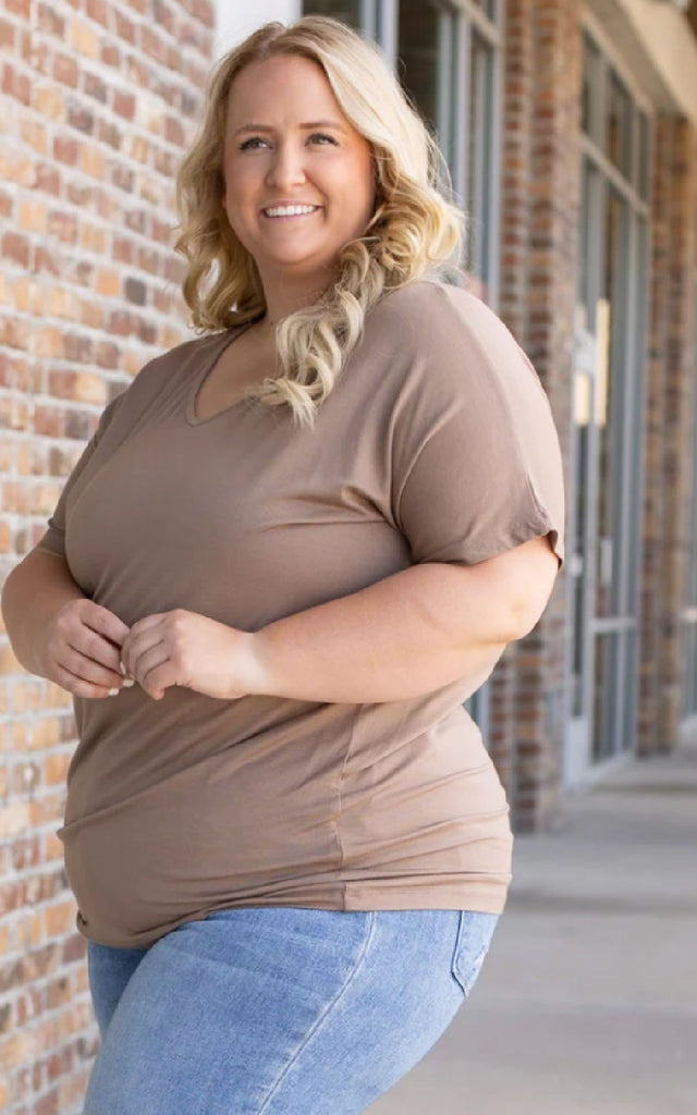 Woman wearing a mocha colored short sleeve top.