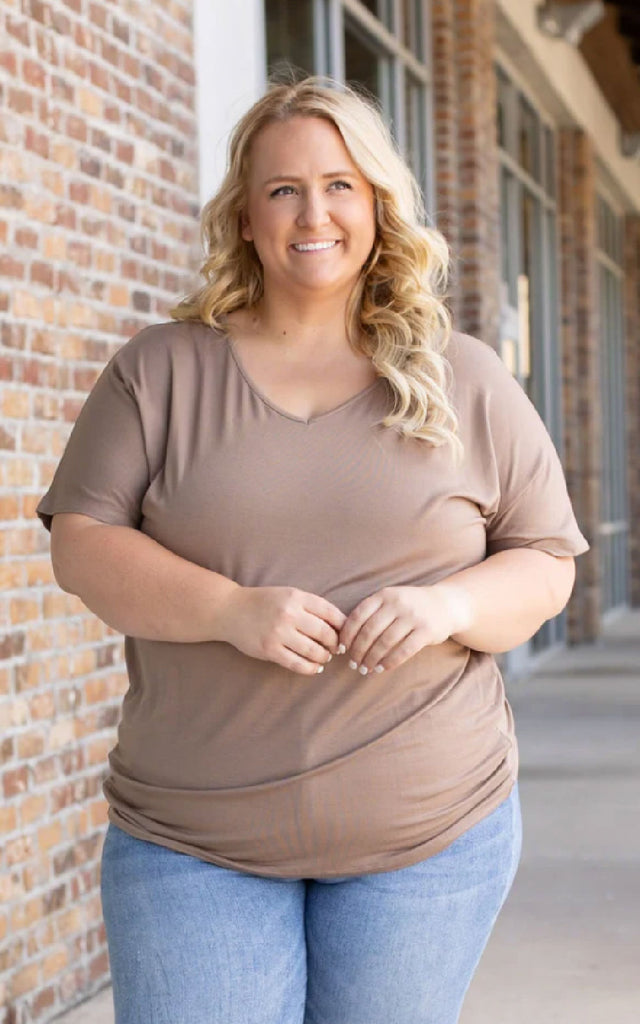 Woman wearing a mocha colored short sleeve top.