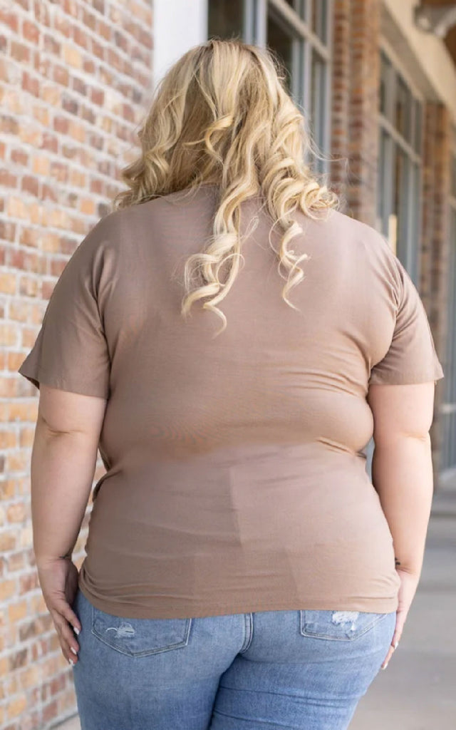 Woman wearing a mocha colored short sleeve top.