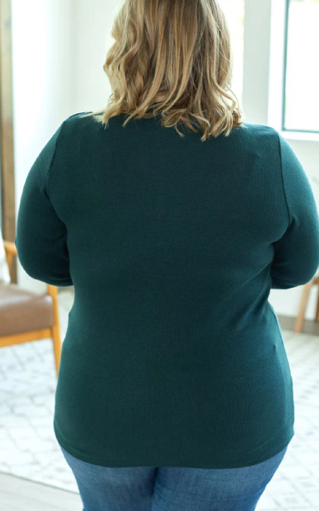 Woman wearing a long sleeve henley shirt with thumbholes.