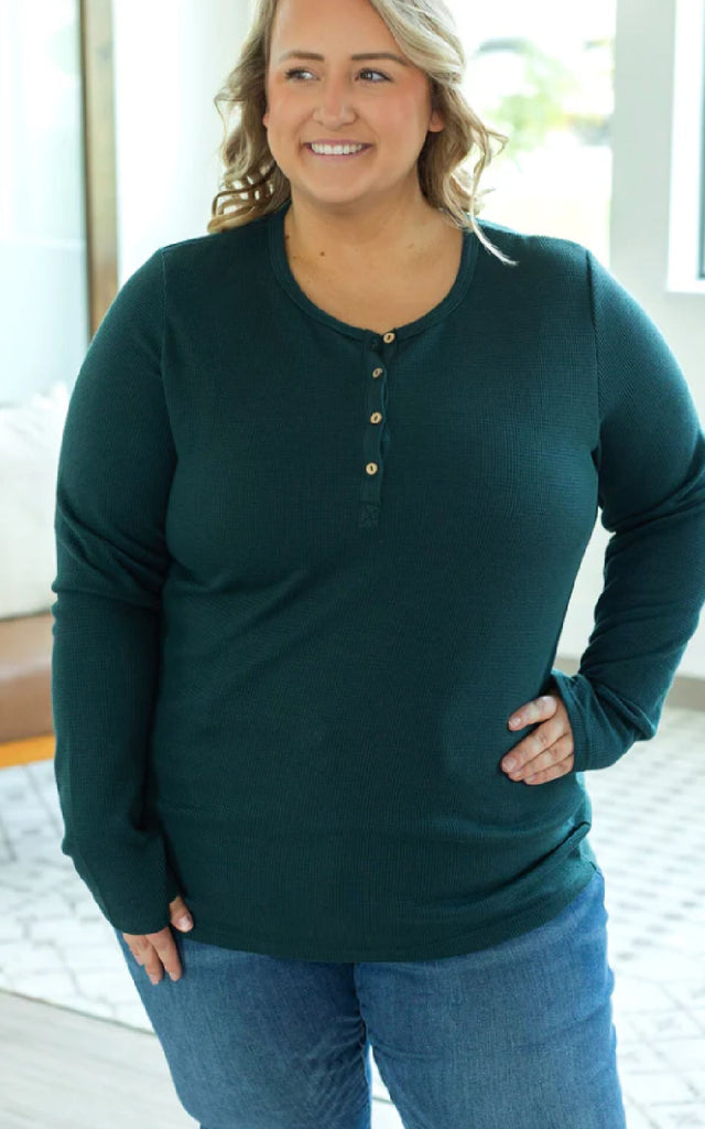 Woman wearing a long sleeve henley shirt with thumbholes.