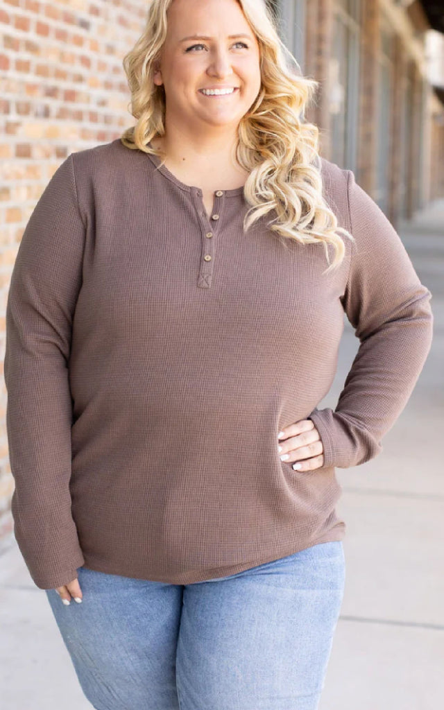 Woman wearing a mocha brown long sleeve waffle knit top.