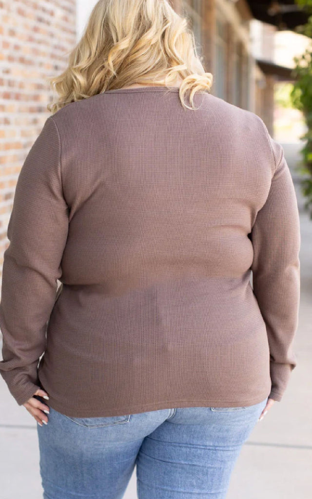 Woman wearing a mocha brown long sleeve waffle knit top.