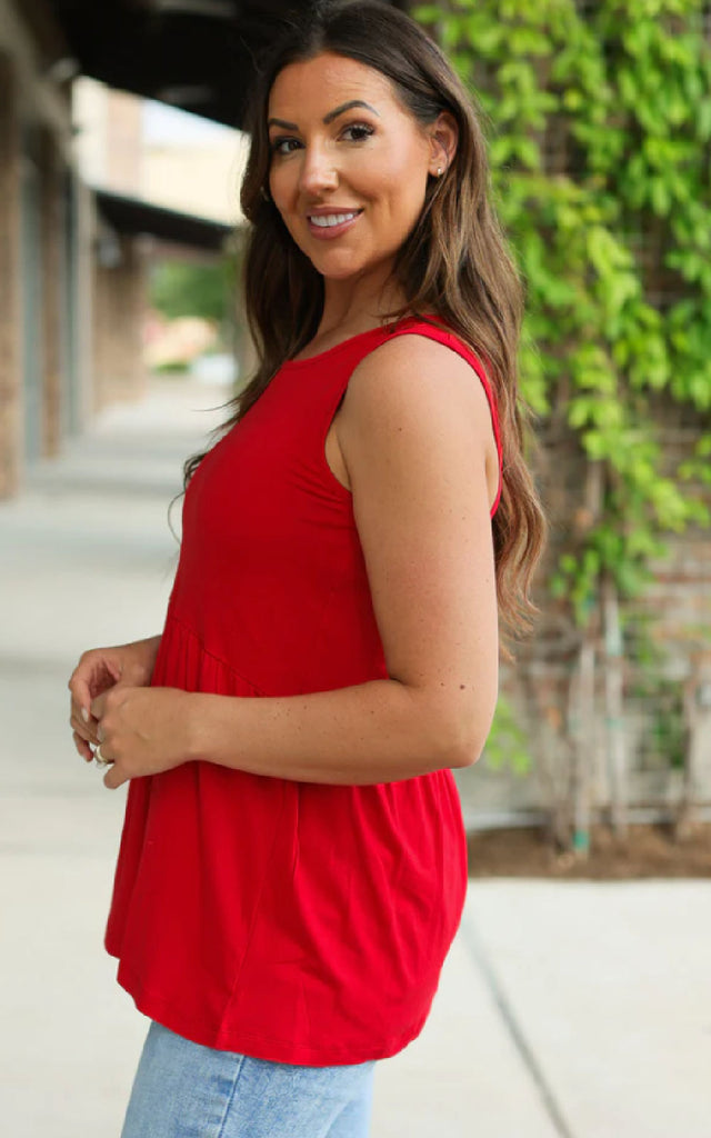 Woman wearing a loose and flowy red tank top.